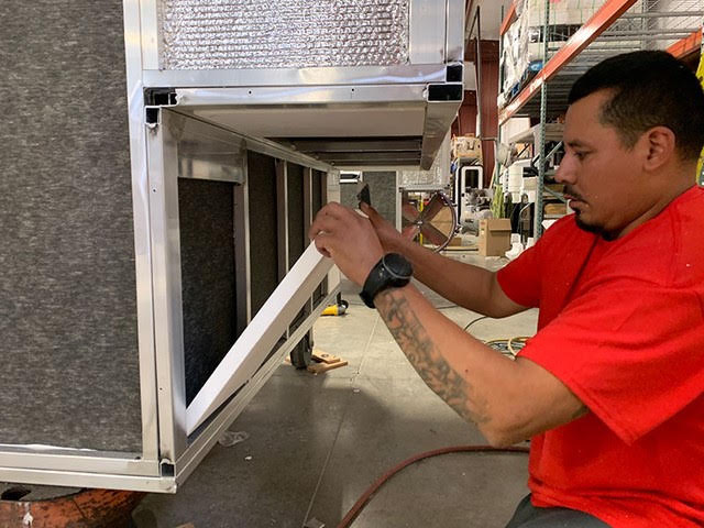 A team member assembling a camper on the factory floor